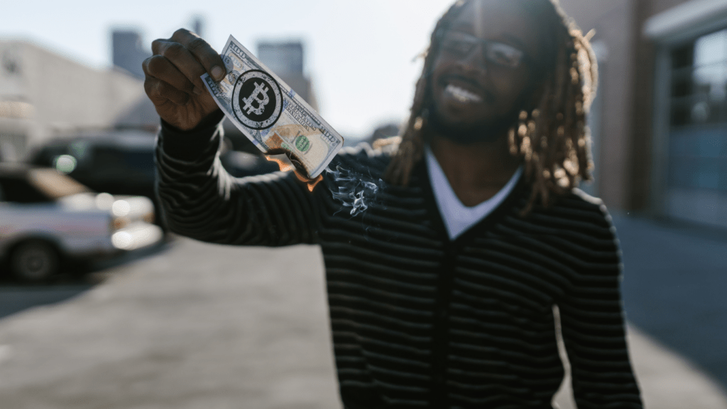 A person holding up a burning money