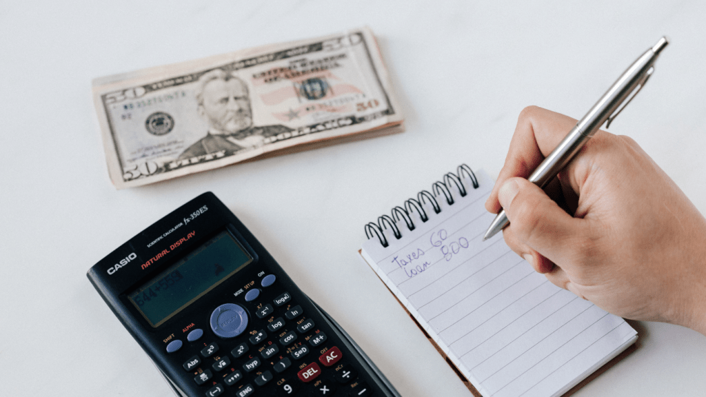 a person sitting at a table with money and receipts