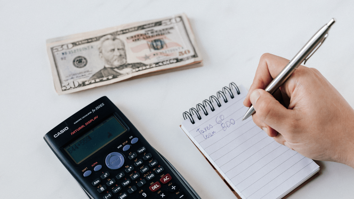 a person sitting at a table with money and receipts