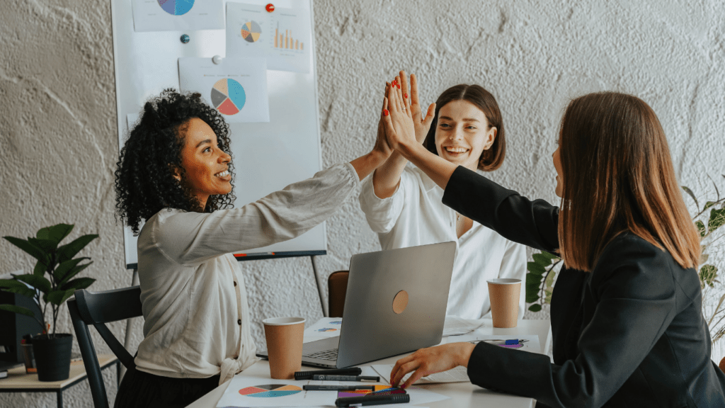 a group of people in an office raising their hands