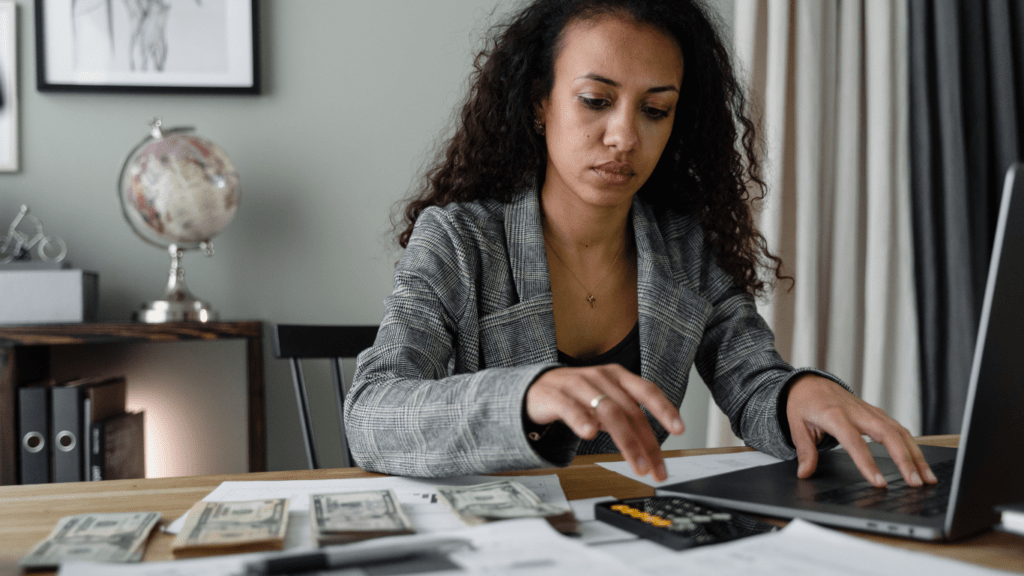 A person is using a calculator while sitting at a desk.