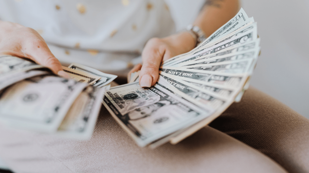 A person is counting money on a table.