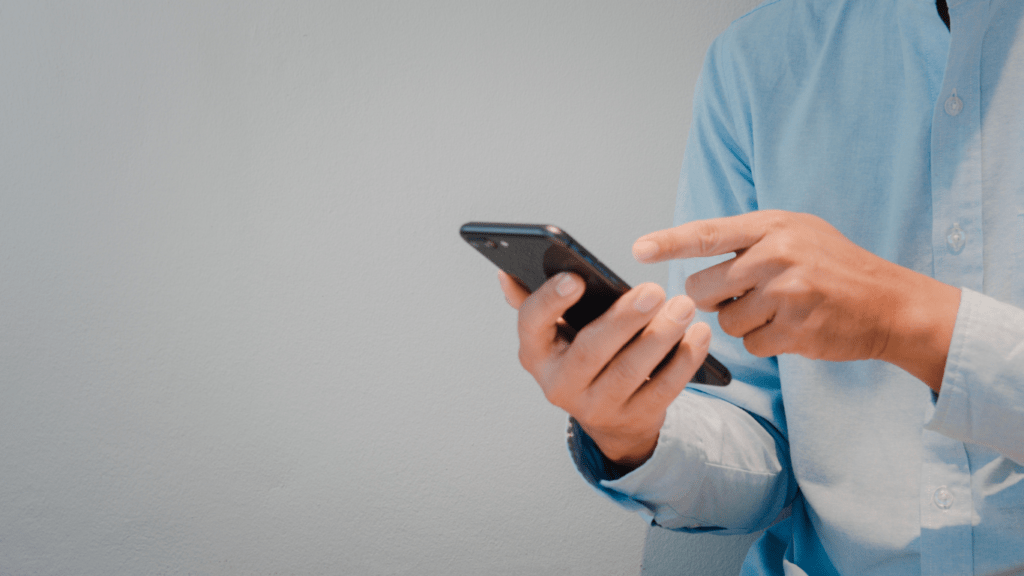 A person sitting on a couch holding a cell phone