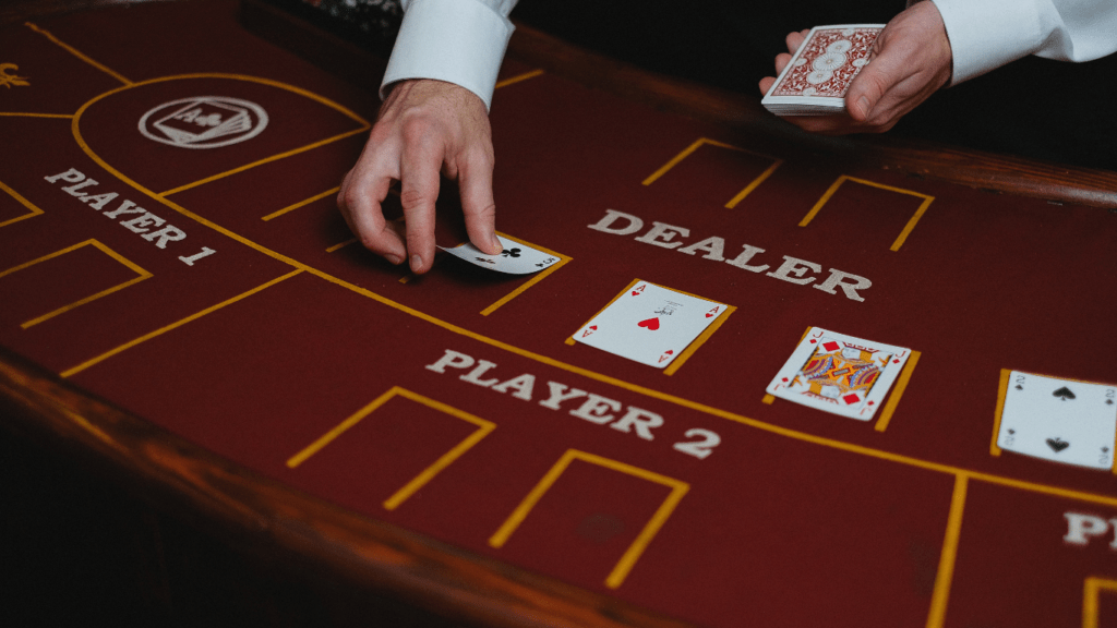 A person in a vest and tie playing cards on a casino table.