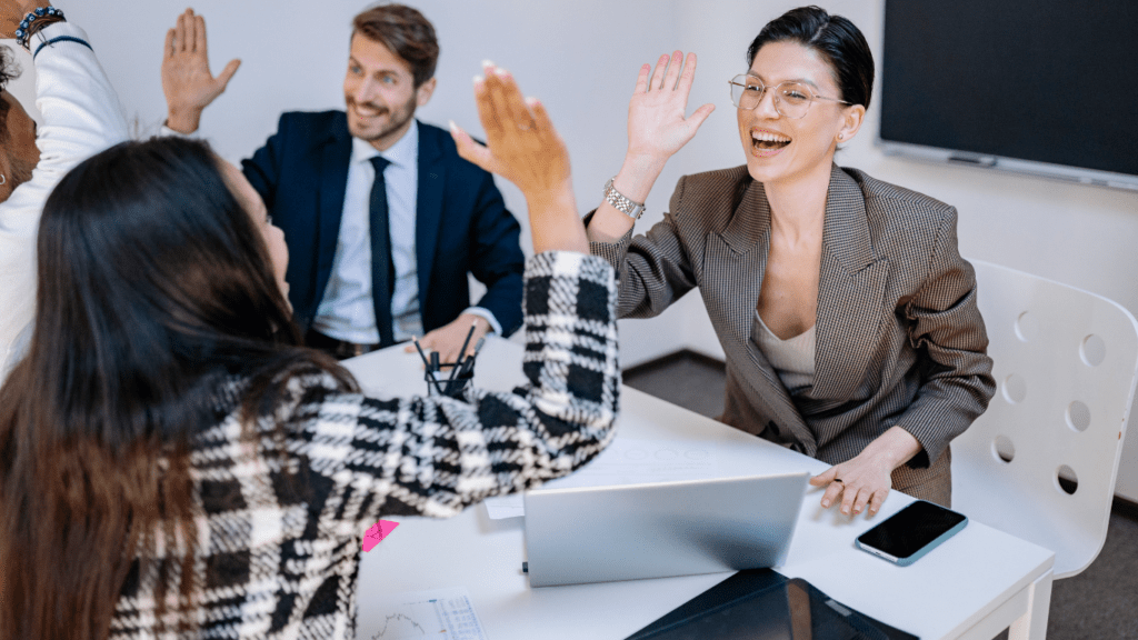 a group of people in an office raising their hands