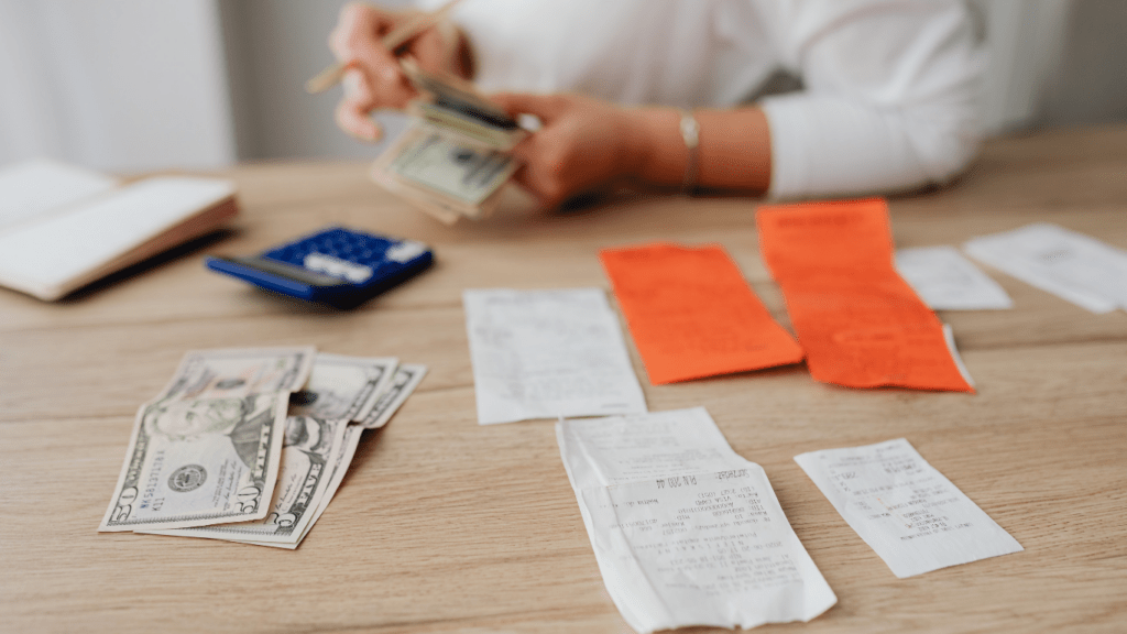 a person sitting at a table with money and receipts