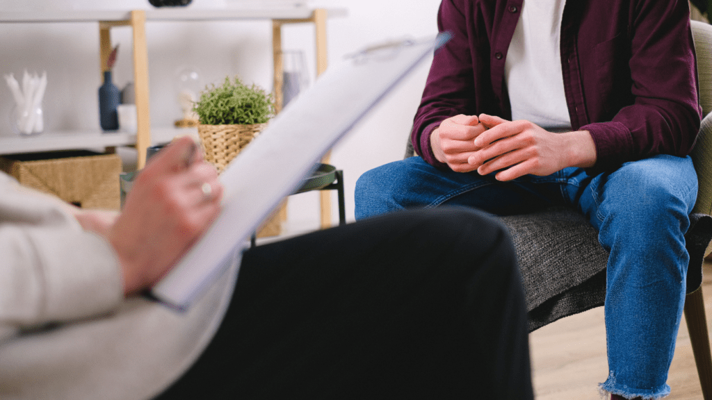 a person sitting in a chair talking to another person