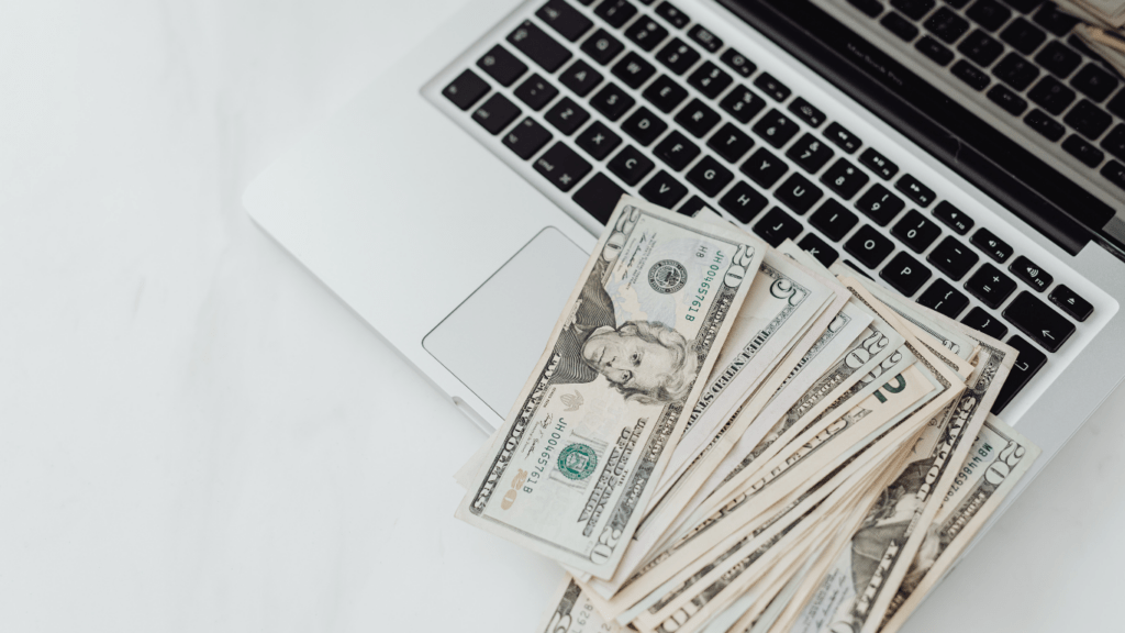 image of a laptop with money